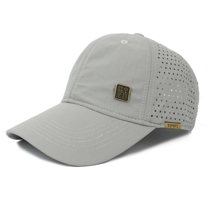 Close-up of laser-cut side vents and sports label on a light gray baseball cap