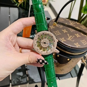 Detail of luxury ladies watch with rose gold diamond bezel and green leather strap