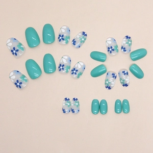Oval press-on nails in pastel sage green and delicate blue floral pattern design