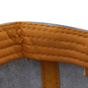 Vista dettagliata dell'interno del cappello denim con cuciture gialle rinforzate