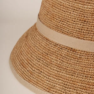 Detailed close-up of woven raffia straw texture and premium beige fabric edge finishing