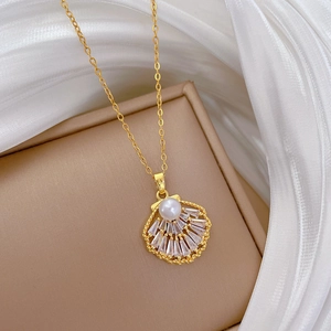 Detailed view of hollow shell pendant with white pearl and sparkling zircons on gold necklace