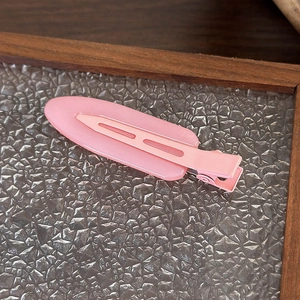 Dettaglio di un fermaglio ovale rosa su un vassoio di vetro testurizzato con cornice