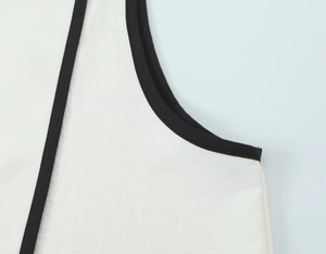 Detailopname van de zwarte contrasterende bies op witte crêpe top met verfijnde stiksels