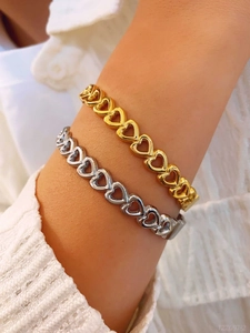 Close-up of minimalist heart-shaped chain bracelets in gold and silver stainless steel