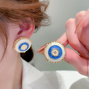 Détail de boucles d'oreilles rondes vintage avec émail bleu et blanc et bordure dorée