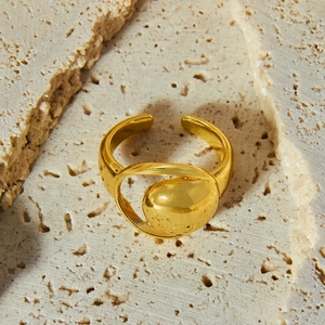 Minimalist gold moon cutout ring with irregular oval geometric design on stone background
