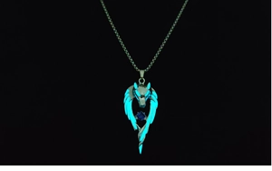Detailed view of luminous wolf head pendant with wings and center blue gemstone