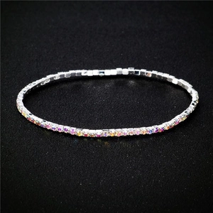 Macro shot of 2.0mm silver bracelet with colorful rhinestones on black background