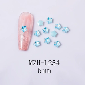Detailed view of 5mm aurora blue star nail rhinestones on pink glitter manicure