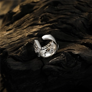 Detailed close-up of a silver zircon ear cuff on a dark charcoal background