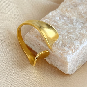 French style wide wavy 18K gold plated ring shown from 45-degree angle on mineral stone