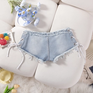 Dettaglio degli shorts in denim azzurro con lacci laterali e bordi sfrangiati alla moda