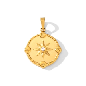 Detailed view of a gold compass pendant with a clear center stone and N E S W engravings