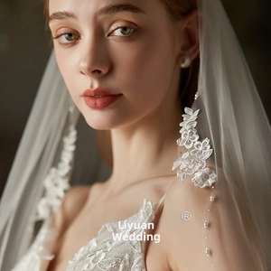 Detail of bridal veil featuring delicate 3D floral lace embroidery and hand-sewn pearls