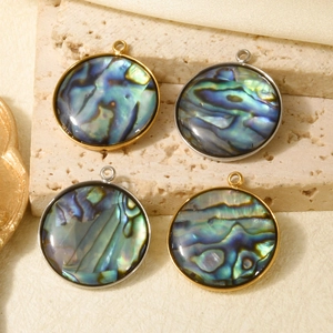 Abalone shell geometric round pendants in gold and silver finish on a stone pedestal