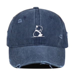 Detailaufnahme von Panda-Stickerei und Vintage-Löchern auf marineblauer Baumwollkappe