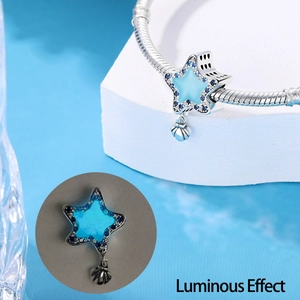 Glow-in-the-dark star charm with blue zircon, showing luminous effect on snake chain