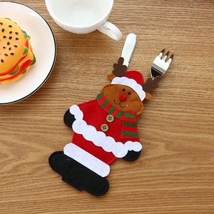 Christmas reindeer felt cutlery holder with red scarf detail on a rustic wooden table