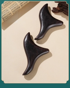 Detailed view of two sandalwood triangular massage tools on a traditional oriental background