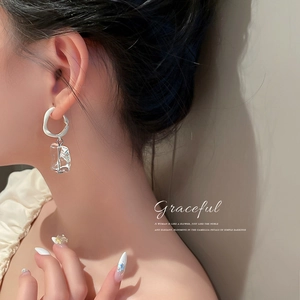 Irregular acrylic ice cube earrings with silver needle on female model in warm lighting