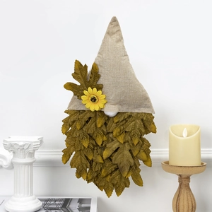 Detail view of autumn gnome wall decor with burlap hat and faux sunflower on a white wall