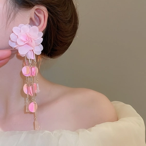 Close-up of pink chiffon flower earrings with shimmering sequins and long tassels