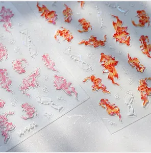 Macro shot of 3D embossed koi fish nail stickers with gold stamping and laser finish