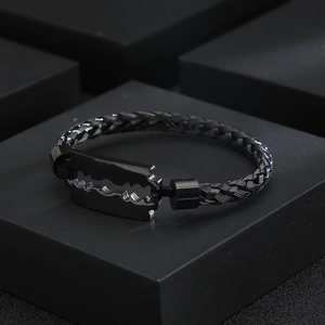 Detail eines schwarzen geflochtenen Armbands mit hochglanzpoliertem Rasierklingen-Element