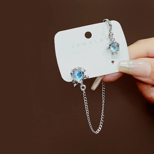 Detailed close-up of liquid metal ear cuff featuring iridescent blue moonstones