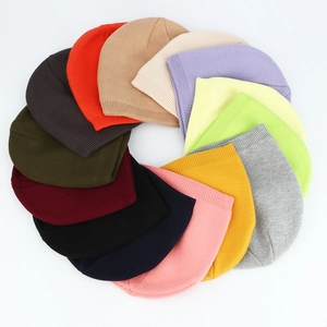 Flat lay display of 15 colorful winter knit beanies in various vibrant and neutral shades