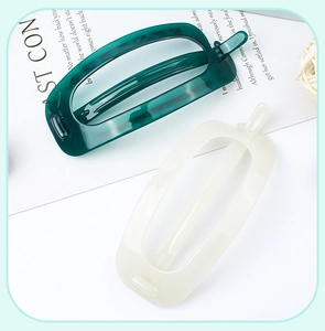 Detail of square hollow hair clips in dark green and cream white matte finish