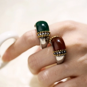 Close-up of retro cat eye stone ring with diamond accents on model hand