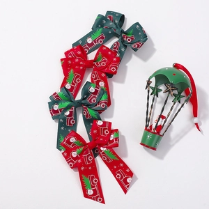 Détails de nœuds de Noël en ruban rouge et vert avec motifs Père Noël et camions