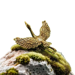 Elegant flying brass crane figurine with detailed wings on natural mossy stone base