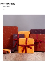 Deep red gift wrapping paper with gold glitter finish and elegant ribbon bow on a box