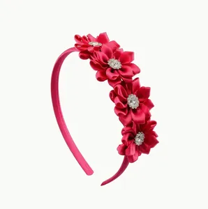 Hot pink satin flower headband for girls featuring sparkling rhinestone center detail