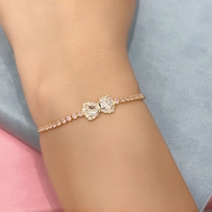 Close-up of rose gold bow bracelet with heart-shaped crystals and pink diamonds on wrist