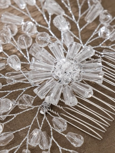 Close-up of handmade bridal hair comb with silver wire, crystals and pearl flowers
