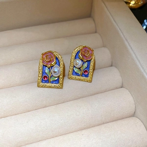 Detail of vintage flower stud earring featuring pink enamel rose and red rhinestones
