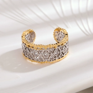 Detailed macro shot of hollow geometric textures and sparkling zircon on a two-tone ring
