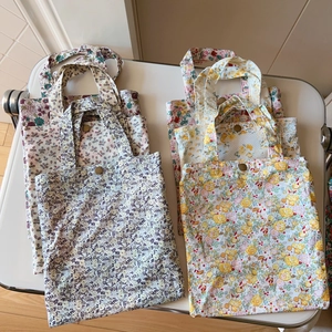 Close-up of floral pattern cotton tote bags with gold metal buckle closure detail