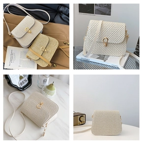 Detail of woven straw crossbody bags with gold U-shaped clasps in beige and light brown