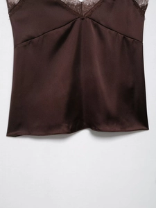 Détail du caraco en satin marron avec bordure en dentelle et texture soyeuse