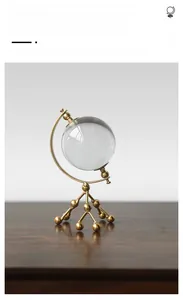 Detail view of gold metal molecular base holding clear crystal balls for home decor
