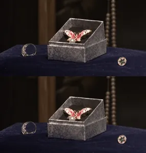 Detail of a pink butterfly brooch with enamel finish and pearl drop in a jewelry gift box
