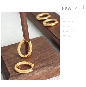 Detailed macro view of two pairs of U-shaped gold-plated stainless steel earrings