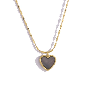 Macro detail of golden heart necklace with black shell inlay and vintage beaded edge