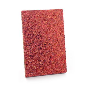 Sparkling red and orange iridescent sequin notebook with metallic luster on white background