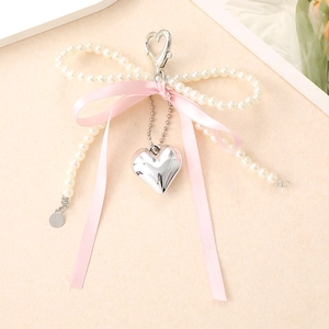 Porte-clés avec nœud en ruban rose, perles blanches et pendentif cœur argenté